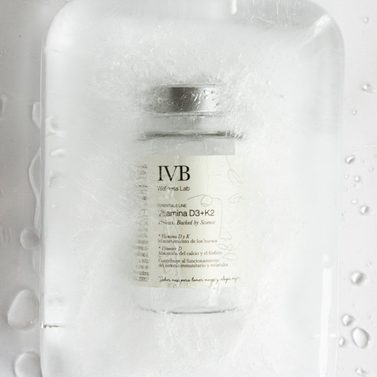 Bote de Vitamina D3+K2 de IVB Wellness Lab rodeado de hielo y gotas de agua.